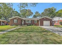 Charming brick home with a well-manicured lawn and an attached garage, creating a welcoming curb appeal at 1421 Fairfield Ave, Charleston, SC 29407