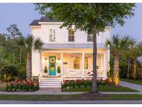Charming two-story white home featuring a welcoming front porch, manicured landscaping, and a bright turquoise front door at 1526 Old Rivers Gate Rd, Mount Pleasant, SC 29466