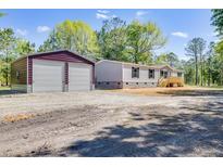 Charming single-story home with an oversized two car detached garage and a large unpaved driveway at 254 Nelson Farm Ln, Cross, SC 29436