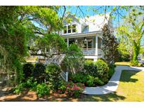 Charming two-story home with a welcoming front porch, landscaped yard, and stairway at 29 Morrison Ave, McClellanville, SC 29458