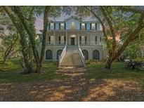 Stately two-story home with white trim, porch, and grand staircase, framed by beautiful mature trees at 4386 Park Island Rd, Hollywood, SC 29449