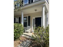 Charming front porch featuring classic columns, a black front door, and complemented by lush green bushes at 4816 Cane Pole Ln, Summerville, SC 29485