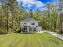 Charming two-story home with manicured lawn, attached garage, and inviting front porch at 5005 Buckland Trl, Ridgeville, SC 29472