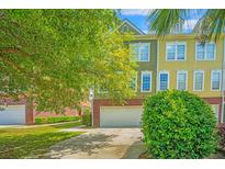 Charming townhome featuring a two-car garage and inviting curb appeal with mature trees at 9042 Parlor Dr, Ladson, SC 29456