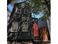 Charming, narrow two-story home with a striking coral door and beautifully textured dark green siding at 152 Coming St St, Charleston, SC 29403