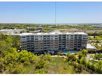 Stunning aerial view of a modern condo building with a pool, surrounded by lush greenery and a beautiful waterfront at 155 Wingo Way # 415, Mount Pleasant, SC 29464