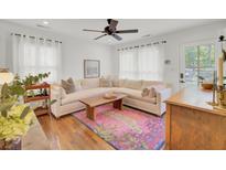 Bright living room with white walls, hardwood floors, and a colorful area rug at 210 Peters St, Summerville, SC 29483
