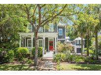 Charming two-story home with a inviting front porch, beautiful landscaping, and a bright red front door at 22 Frogmore Rd, Mount Pleasant, SC 29464