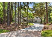 Charming single-story home with a long, paved driveway and lush landscaping at 2575 The Haul Over, Seabrook Island, SC 29455