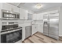 Bright kitchen features stainless steel appliances, white cabinets, quartz countertops, and stylish lighting at 415 Parkdale Dr # 2B, Charleston, SC 29414