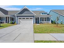 Charming blue home with a two-car garage and inviting front porch at 4996 Song Sparrow Way, Summerville, SC 29483