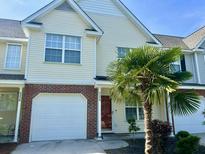 Inviting home featuring a one-car garage, brick accents, and a well-manicured lawn with a mature palm tree at 5226 Fernland Way, North Charleston, SC 29420