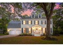 Charming two-story home with a two-car garage and meticulously landscaped front yard, bathed in the soft glow of twilight at 595 Crowned Kinglet Retreat, Charleston, SC 29412