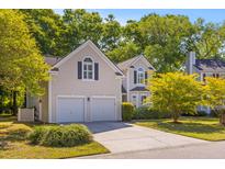 Charming two-story home featuring an attached two car garage and well-manicured front yard at 715 Majestic Oak Dr, Charleston, SC 29412