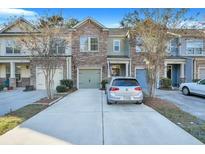 Charming townhome with a stone facade, attached garage, and long driveway at 853 Bibury Ct, Charleston, SC 29414