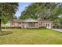 Charming brick home featuring a well-manicured front lawn with mature trees and lovely curb appeal at 110 Jackson Rd, Ladson, SC 29456