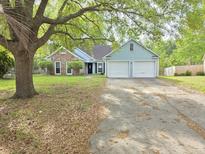 Charming single-story home featuring a two-car garage, brick accents, and mature trees in a suburban setting at 113 Saxton Ct, Goose Creek, SC 29445