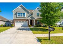 Charming two-story home with brick and siding, a well-manicured lawn, and an attached two-car garage at 1146 Moss Grove Dr, Moncks Corner, SC 29461