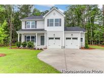 Charming two-story home featuring a two-car garage and a well-manicured lawn with mature trees at 120 Mcmakin Dr # 16, Summerville, SC 29483