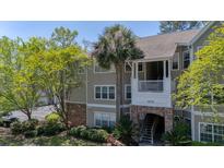 Charming condo exterior with a lovely brick archway and lush green landscaping and trees at 188 Midlands Pkwy # 507, Summerville, SC 29485