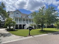 Charming two-story home with a welcoming front porch, lush green lawn and beautiful curb appeal at 2408 Bending Oak Loop, Mount Pleasant, SC 29466