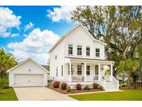 Charming two-story home with white siding, a inviting front porch and a detached garage at 2815 Colonel Harrison Dr, Johns Island, SC 29455