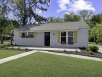 Charming one-story home featuring a well-manicured lawn and flower boxes under the windows at 3105 Matipan Ave, North Charleston, SC 29405