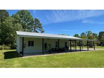 Spacious single-story home with covered porch and ample green lawn and mature tree coverage at 4911 Chisolm Rd, Johns Island, SC 29455