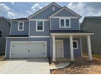 Charming two-story home with blue siding, white trim, and a spacious two-car garage at 575 Red Monarch Way, Moncks Corner, SC 29461