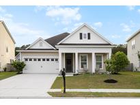 Charming single-story home with a well-manicured lawn and covered porch at 589 Crossland Dr, Moncks Corner, SC 29461