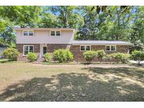 Charming two-story home with a brick facade, lush landscaping, and a well-maintained lawn at 679 Edmonds Dr, Charleston, SC 29412