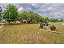 Expansive front yard with mature trees and Rockin H Farm sign in front of home with white picket fence at 7875 Berry Manor Ln, Edisto Island, SC 29438