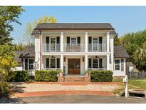 Charming two-story home showcasing a double porch, manicured landscaping, and a welcoming brick driveway at 930 Richter Way, Mount Pleasant, SC 29464
