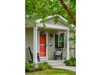 Inviting front porch with a bright red door, rocking chairs, and hanging flower baskets at 14 Paula Dr, Charleston, SC 29407