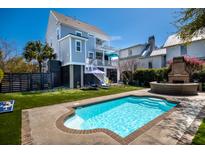 Backyard pool with turfed lawn, patio, brick fire pit, and lounge seating at 1427 Wando View St, Charleston, SC 29492