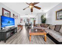 Inviting living room featuring hardwood floors, ceiling fan, a comfortable sofa, and a modern entertainment center at 1516 Mandarin Ct, Summerville, SC 29483