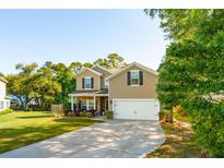 Charming two-story home features a well-manicured lawn, inviting curb appeal, and an attached two-car garage at 1606 Stovall Ct, Johns Island, SC 29455