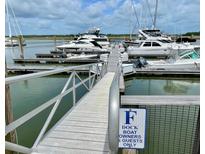 View of the boat dock with several yachts under a cloudy blue sky at 1880 Andell Bluff Blvd # F-3, Seabrook Island, SC 29455