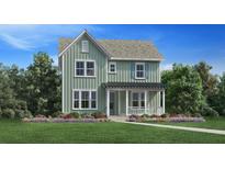 Charming two-story home with a covered front porch, well-manicured lawn, and colorful flowerbeds at 2014 Riverbend Dr, Charleston, SC 29412