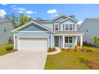Charming two-story home with a well-manicured lawn and attached two-car garage at 208 Cherry Grove Dr, Summerville, SC 29483