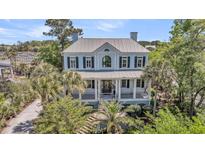 Stately two-story home with a metal roof, inviting front porch, and lush landscaping at 2254 Beckenham Dr, Mount Pleasant, SC 29466