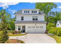 Charming two-story modern farmhouse exterior with black roof, white siding, and a well manicured front yard at 481 Woodland Shores Rd, Charleston, SC 29412