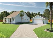 Charming home with a light blue facade, complemented by a matching detached garage and spacious driveway at 5213 Seewee Rd, Awendaw, SC 29429