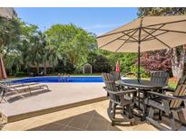 Backyard pool featuring outdoor seating and a lush green area with mature trees, ideal for entertaining at 5401 Diston Court, North Charleston, SC 29420