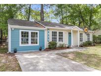 Charming single-story home with a delightful blue accent and a well-manicured front yard at 5817 Canterbury Dr, Hanahan, SC 29410