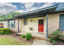 Charming covered front porch with brick accents, updated paint, and well-manicured landscaping at 7655 Ovaldale Dr, North Charleston, SC 29418