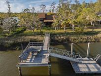 Picturesque waterfront home featuring a private dock, boat lift, and scenic views at 7897 Russell Creek Dr, Edisto Island, SC 29438