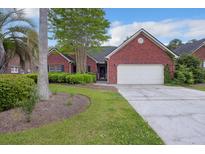 Charming brick home with a two-car garage, mature landscaping, and a well-manicured lawn at 103 Innisbrook Bnd, Summerville, SC 29483