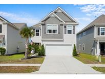 Charming two-story home featuring a grey shingled roof, attached two-car garage, and a well-manicured front lawn at 1052 Sago Palm Ct, Mount Pleasant, SC 29429