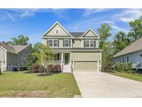 Charming two-story home features a covered front porch and a two-car garage at 1489 Brockenfelt Dr, Charleston, SC 29414